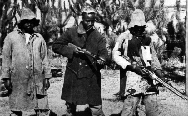 The Two Pseudo gang members at the left are ex-Mau Mau, the man at the far right is a white British soldier disguised as an African.